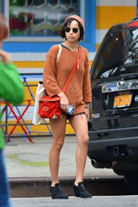 Zoe Kravitz walking in shorts and an orange top