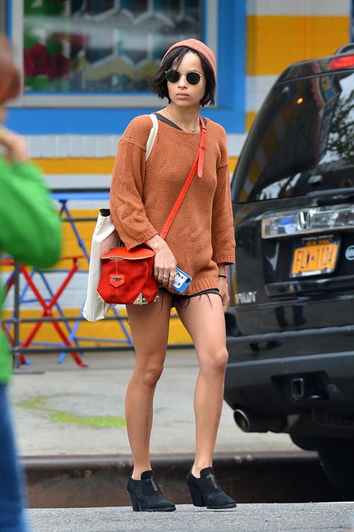Zoe Kravitz walking in shorts and an orange top