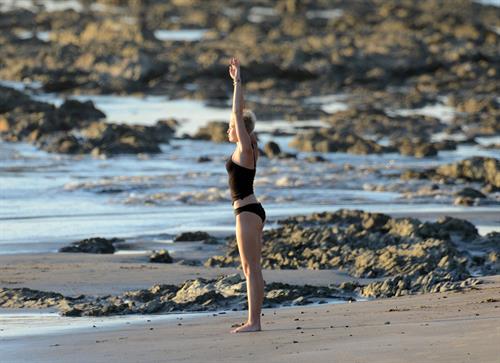 Miley Cyrus  yoga in black bikini on beach in Hawaii 1/24/13 