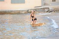 Kimberley Garner in a black bikini on the beach in St. Tropez on July 31, 2014