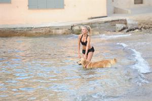 Kimberley Garner in a black bikini on the beach in St. Tropez on July 31, 2014