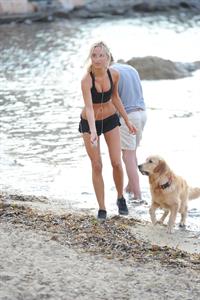 Kimberley Garner in a black bikini on the beach in St. Tropez on July 31, 2014