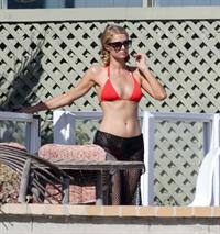 Paris Hilton at the beach in a skimpy red bikini and fishnet kaftan in Malibu.July 12, 2013