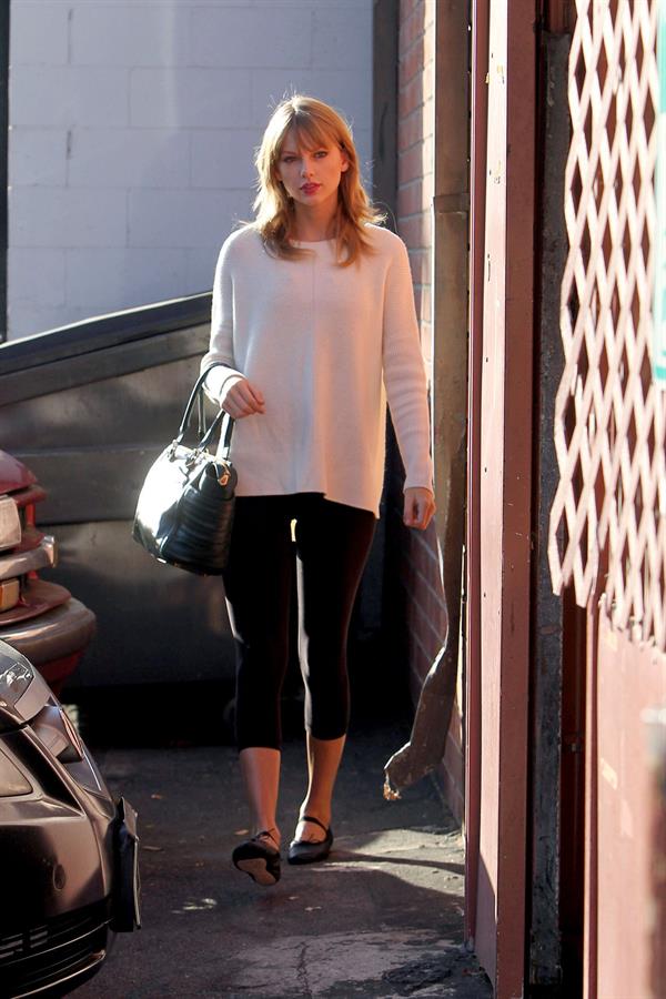 Taylor Swift wearing a white top and black pants in Los Angeles 10/28/13  