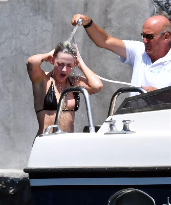 Kristen Stewart nude boobs caught topless by paparazzi tanning on a boat.
