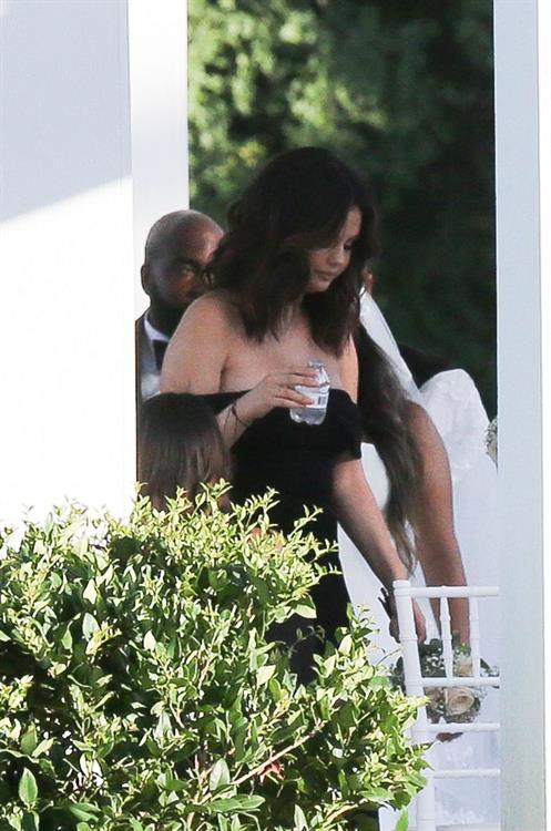 Selena Gomez Pictures Selena Gomez sexy in a black dress for her cousins wedding showing nice cleavage seen by paparazzi.