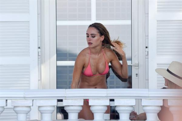 Kimberley Garner sexy model body in a pink bikini at beach seen by paparazzi.




