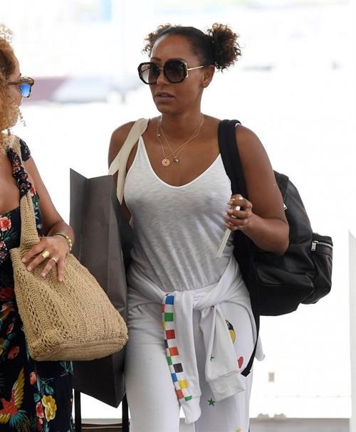 Melanie Brown Pictures Mel B braless boobs in a see through white top showing off her tits seen by paparazzi at the airport.