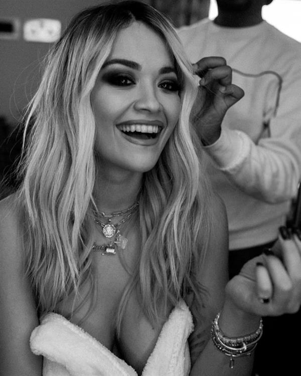 Rita Ora nude in just a robe backstage showing some nice cleavage.


