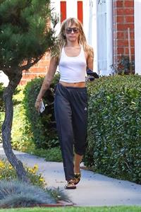 Miley Cyrus braless boobs in a slightly see through white top showing off her tits seen by paparazzi.
