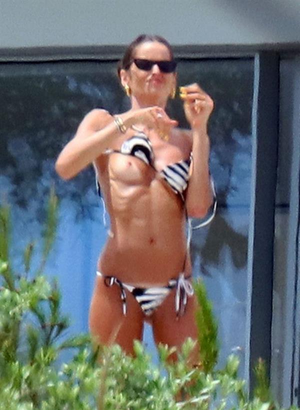 Izabel Goulart nude boobs caught by paparazzi in Saint Tropez as she is doing up her bikini accidentally exposing her topless tits also showing off her sexy ass in a thong bikini.