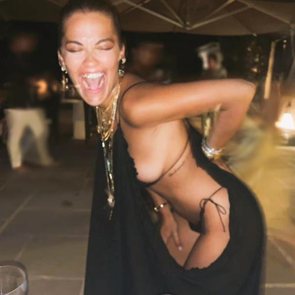 Rita Ora sexy new photo laughing while wearing a tiny little thong bikini showing nice side boob with her big tits.