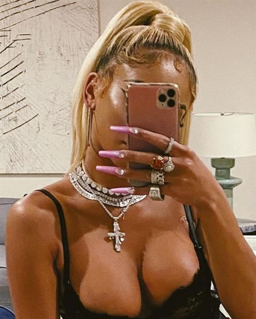 Saweetie boobs showing nice cleavage with her big tits and sexy ass booty in a hot black see through dress.
