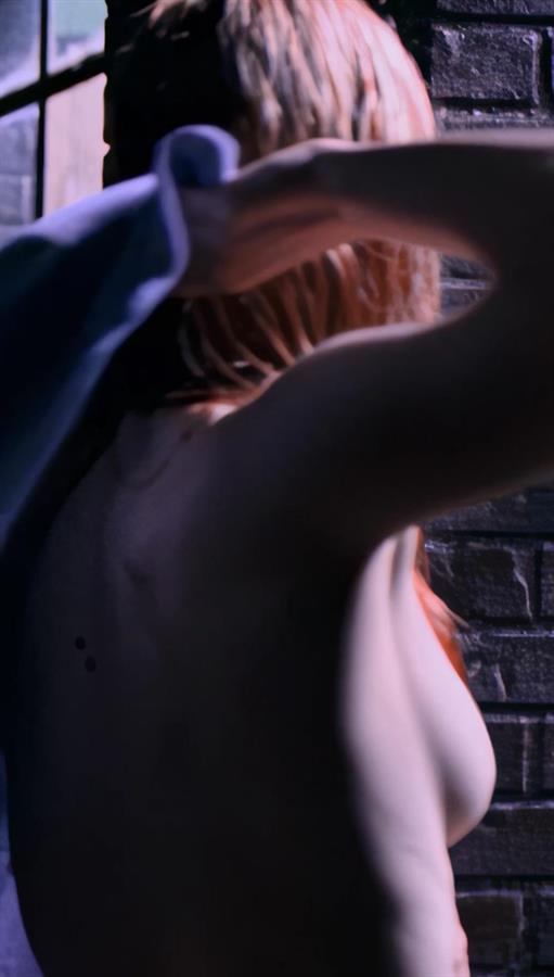 A moody, dimly lit shot from Daredevil Season 1, Episode 1. Deborah Ann Woll is caught mid-motion with her arms raised, creating a natural, unposed angle that reveals a subtle glimpse of sideboob.